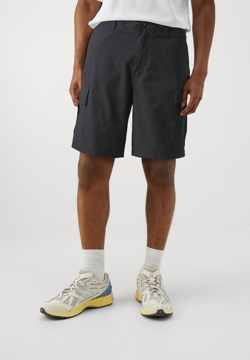 Marina cargo shorts i ett hållbart tyg, med sido-fickor och rak fåll. Kombineras med vita strumpor och flerfärgade sportskor.