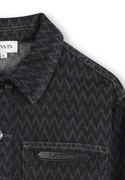 Chemise en denim noire à motif avec un design en zigzag, col pointu, patch de marque sur la poche poitrine et fermeture à boutons.