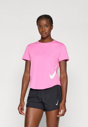Pink athletic t-shirt with short sleeves and crew neckline, featuring a white Nike logo on the side. Paired with black shorts.