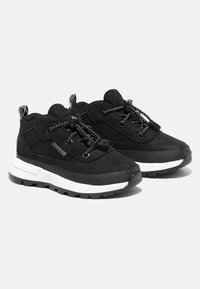 Black athletic shoes with textured fabric upper, white midsole, and black rubber outsole. Features elastic laces and pull tab on the heel.