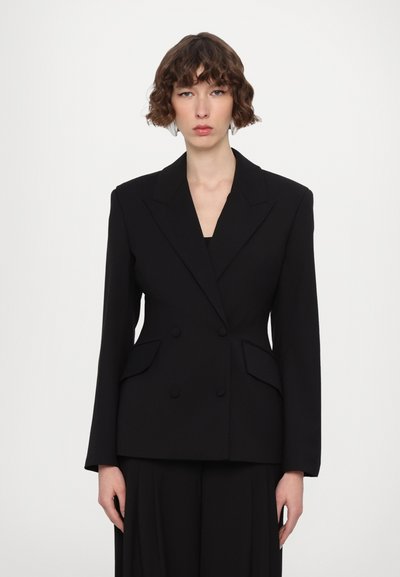 Černý dvouřadý blazer s přiléhavým střihem, špičatými klopami a dvěma klopovými kapsami. Vyroben z jemné tkaniny se tvarovanými ramenními vycpávkami.