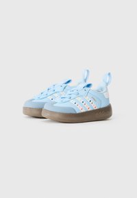 Baskets de sport bleues avec un dessus lisse ornées de rayures colorées, semelle en caoutchouc et languettes de tirage pour un enfilage facile.