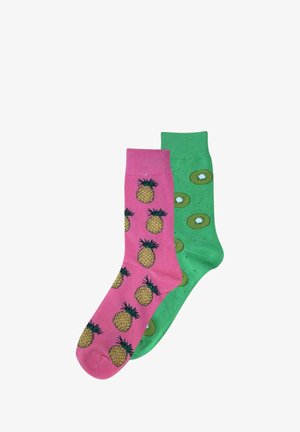 Roze sok met ananaspatroon, gekoppeld aan een groene sok met kiwi-slices en spikkels. Beide gemaakt van zachte stof.