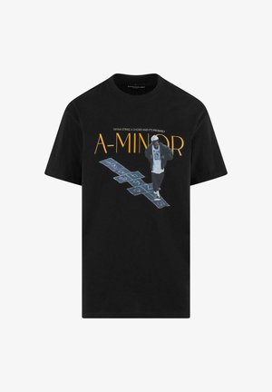 Czarny T-shirt z graficznym nadrukiem przedstawiającym postać skaczącą oraz napisem "A-MINOR" na żółto, w towarzystwie dodatkowego tekstu powyżej.