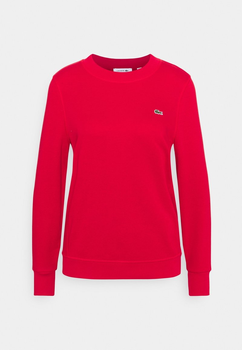 Sweat-shirt rouge en tissu doux, doté d'un col rond, de manches longues et d'un petit logo vert brodé sur la poitrine.