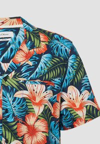 Camicia a maniche corte in cotone con un motivo floreale tropicale blu e verde, con accenti arancioni e rosa. Include una tasca sul petto.