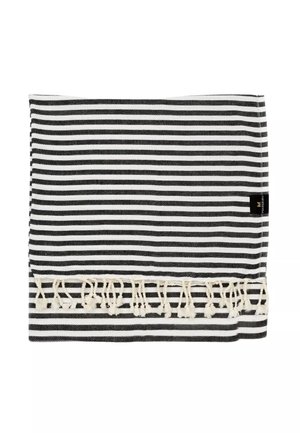 Čierno-biela pruhovaná látka s krémovými strapcami na jednom okraji a malou čiernou štítkom na pravej strane.