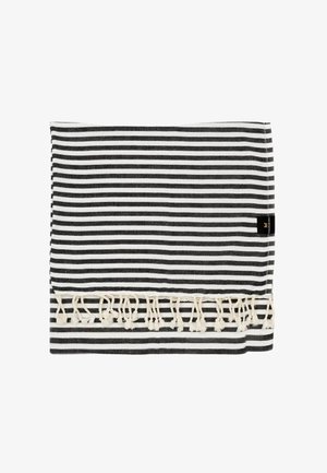 Tela a rayas en blanco y negro con flecos de color crema en un borde y una pequeña etiqueta negra en el lado derecho.