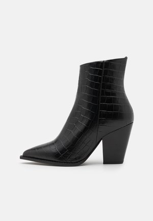 Schwarze Knöchelstiefel mit spitzer Zehe, aus krokodilgeprägtem Lackleder, mit blockiertem Absatz und glatter, glänzender Textur.