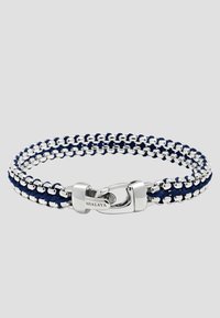 Navy braided leather bracelet with silver metal accents and a clasp closure. Features woven chain links and a logo engraving on the clasp.
