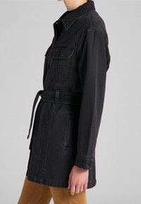 Svart denimjacka med krage, långa ärmar, avtagbart bälte, två framfickor och en avslappnad passform.