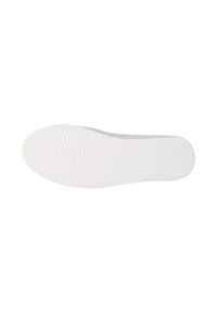 Semelle d'une chaussure blanche avec un motif de grip texturé, montrant des lignes ondulées et des crêtes pour la traction.