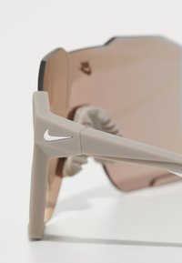 Nike Sportswear CHARGED SHIELD UNISEX - Ochelari de soare - matte college grey / gold-coloured