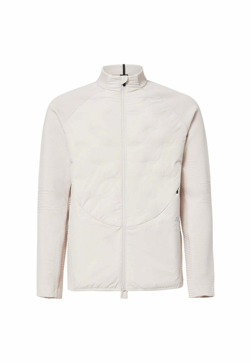 Helle beige Zip-Jacke mit gesteppter Vorderseite, hohem Kragen und geripptem Textil an Ärmeln und Seiten.