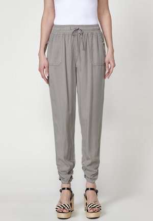 Pantalons légers gris clair, avec une taille élastique et un cordon de serrage, dotés de deux poches avant et de poignet fuselé.