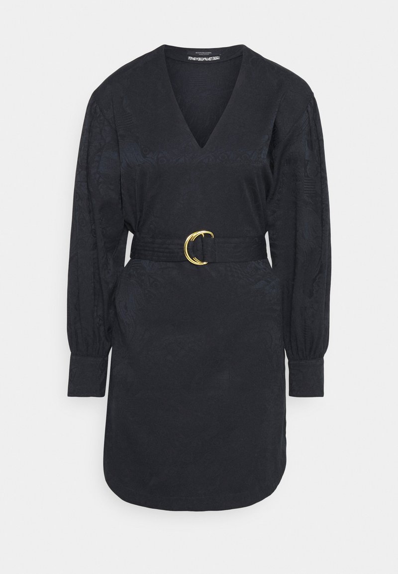 Robe noire à manches longues avec un col en V, ceinture taille ajustée ornée d'une boucle double anneau dorée, et motif texturé subtil sur tout le tissu.