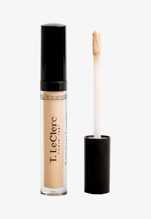 Der Concealer von T. LeClerc in einem transparenten Tube mit schwarzem Deckel, ausgestattet mit einem Applikator in Form eines Rehefußes. Die Produktfarbe ist hellbeige.