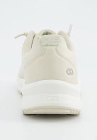 Hellbeige Sportschuhe mit strukturiertem Obermaterial, glatten Lederelementen, einer gepolsterten Sohle und einer Schlaufe als Zuglasche an der Ferse.