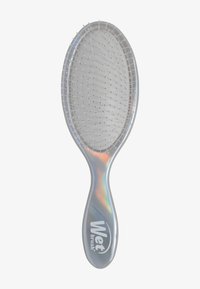 Natte borstel met een doorschijnende, iriserende handgreep. Ovale vorm met fijne haren en een dunne, flexibele basis voor het gemakkelijk ontwarren van haar.