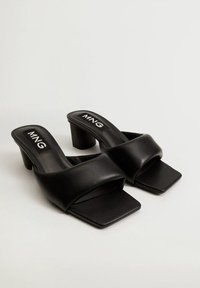 Czarne sandały na obcasie wykonane z gładkiej skóry. Posiadają szeroki pasek i kwadratowy nosek. Niski obcas w formie klocka dla większej stabilności. Logo MNG na wkładce.