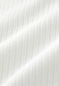 Bílá žebrovaná látka s texturovaným povrchem, s vertikálními pruhy a jemným, hladkým vzhledem. Ideální pro oděvy nebo textil pro domácnost.