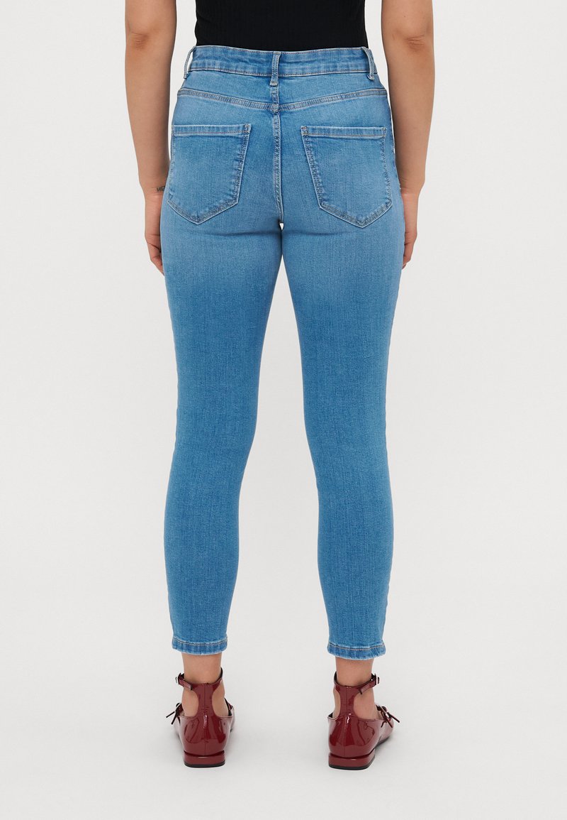 Hochgeschnittene, hellblaue Skinny-Jeans aus Denim. Mit zwei Gesäßtaschen und einer schmalen Passform an den Beinen, mit aufgerollten Säumen.