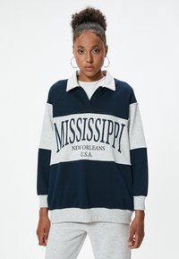 Pullover in cotone blu navy e grigio con colletto, caratterizzato dalla scritta "MISSISSIPPI NEW ORLEANS U.S.A." in stampatello sul petto. Maniche lunghe, vestibilità comoda.