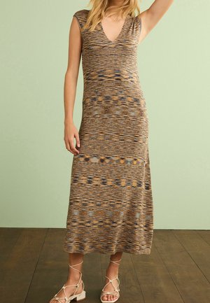 Robe maxi tricotée aux motifs marron et beige, avec un décolleté en V et des manches courtes. Texture lisse avec des accents géométriques.