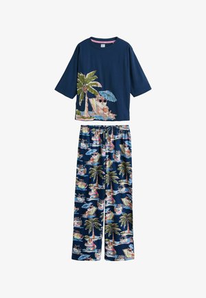 Marineblauw pyjamaset met een kat met zonnebril die onder palmen ligt te ontspannen op het shirt en herhaalde tropische kattenpatronen op de broek.