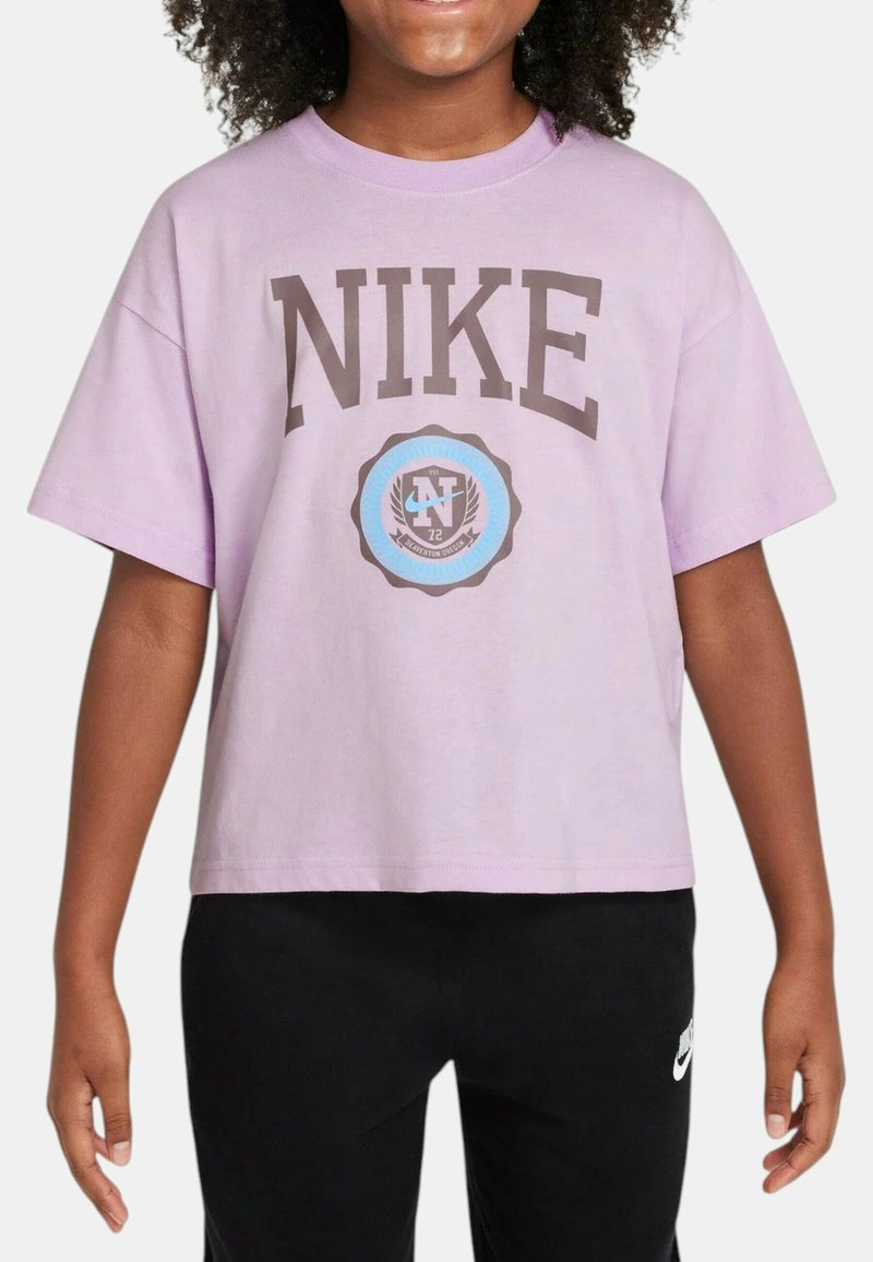 Camiseta de algodón lila claro, de corte holgado, con un audaz logo de "NIKE" en marrón y un emblema circular con acentos en negro y azul debajo.