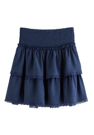 Gonna a balze blu navy con vita arricciata a smock. Tessuto strutturato con bordo in pizzo agli orli. Design svolazzante, leggero e a strati.