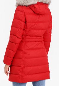 Röd dunkjacka med huva i fejkpäls, med quiltad design, långa ärmar och insvängd midja, som går ner till mitten av låret.