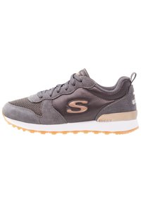 Szare sneakersy z mieszanką materiałów zamszowych i siateczkowych, gumową podeszwą, teksturowanymi akcentami oraz detalem z logo w pobliżu pięty.