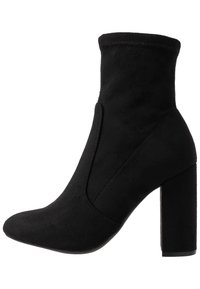 Schwarze Knöchelstiefel aus weichem Wildleder, mit runder Spitze, hoch blockiertem Absatz und nahtlosen Seitenpanelen für ein elegantes Design.