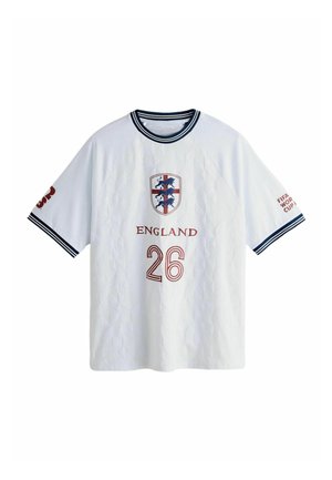 Biały angielski strój piłkarski z granatowym wykończeniem, herbem z trzema niebieskimi lwami, numerem 26 oraz napisem „FIFA World Cup” na rękawie.