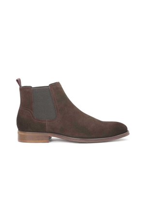 Botines de ante marrón oscuro con paneles laterales elásticos y una asa de tirón. Presentan una punta redondeada y un tacón bajo apilado.