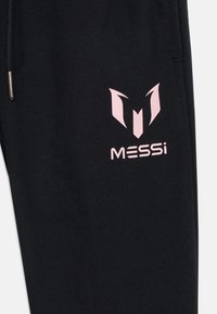 Zwarte sweatpants met een roze logo dat een abstract ontwerp toont met de tekst "MESSi" eronder. Gemaakt van zachte, gestructureerde stof.