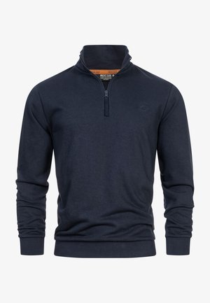Mørkeblå quarter-zip pullover lavet af blødt stof. Har lange ærmer, ribbede manchetter og et lille logo på brystet. Glat tekstur.