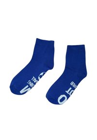 Calze alla caviglia in cotone blu con testo bianco che recita "SOCCER" e una grafica di un pallone; texture liscia, polsini elasticizzati e punte rinforzate.