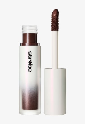Tube de rouge à lèvres liquide marron foncé avec bouchon blanc et applicateur à embout texturé, marquage « str*ke » sur le tube.
