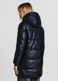 Schwarzer gesteppter Mantel aus glänzendem Kunstleder. Verfügt über eine Kapuze, lange Ärmel und seitliche Taschen mit Knopfverschluss. Schlankes und schnittiges Design.