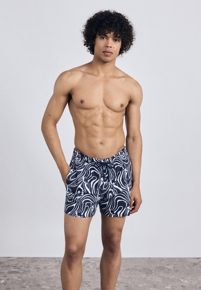 Peldbikses tumši zils pamats ar baltām abstraktām viļņu rakstiem. Izgatavotas no viegla materiāla, ar elastīgu jostu un sānu kabatām.