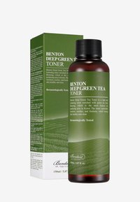 Mörkbrun flaska med svart kork, märkt i grönt med vit text. Åtföljd av en grön förpackningslåda med ett landskapsmönster.