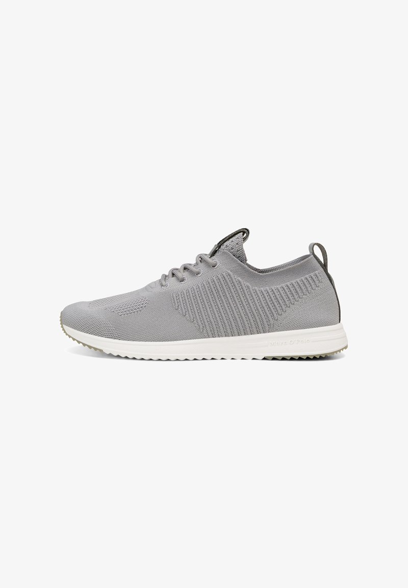 Γκρι αθλητικά sneakers με υφασμάτινο επάνω μέρος με υφή, κυκλικό δάκτυλο, επίπεδη λευκή σόλα και διακριτική σήμανση στη φτέρνα. Σχοινάκια και μια ετικέτα στο πίσω μέρος.