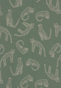 Zielony materiał z powtarzającym się wzorem z konturowymi kotami w odcieniu off-white, przedstawiającymi różne pozy oraz detale, takie jak plamy i wąsy.