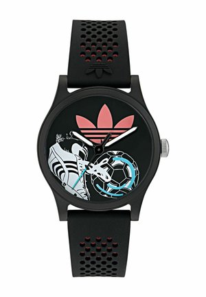 Mustast silikoonist käekell tekstuuriga rihmaga, millel on ümmargune must sihverplaat, valged aktsendid ja värvilised sportlikud graafikud, sh jalgpall.