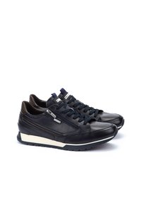Sneaker in pelle blu navy con design con lacci, cerniera laterale e accento bianco sulla suola. Texture liscia con una silhouette elegante.