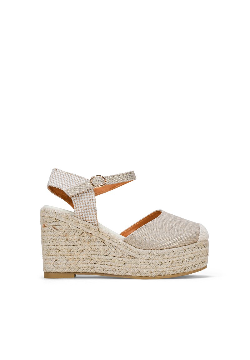 Sandale compensée beige au design espadrille, tige en tissu, bout rond, arrière ouvert et sangle de cheville avec boucle.