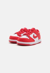 Červené a biele tenisky Nike s hladkým koženým zvrškom, polstrovaným límcom, perforovanou špičkou a gumovou podrážkou s textúrovaným gripom.