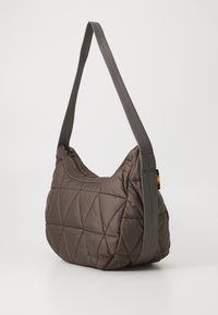 Brown quilted shoulder bag with a textured finish, featuring a single adjustable strap and a zip closure, accented by a small multicolored tag.